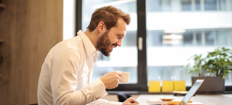 A man drinking coffee and doing research which is important when you want to expand your business to a new neighborhood in Chicago.